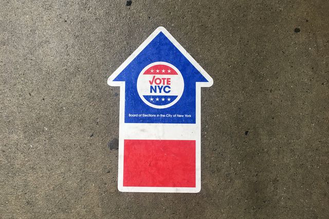 An early voting directional sticker on the sidewalk
